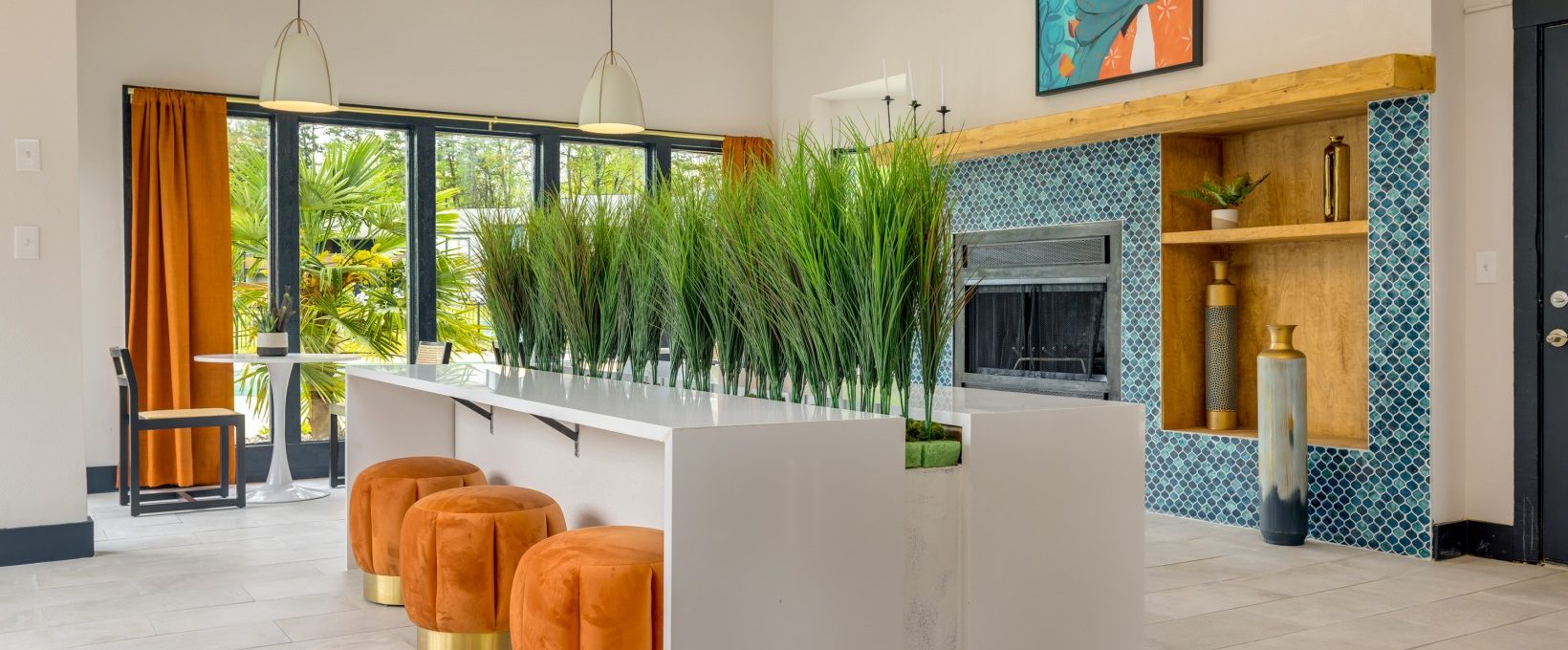 a living room with orange plants and a fireplace at The  Tatum