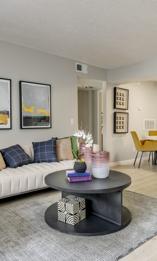 a living room with a couch, coffee table and chairs at The  Tatum